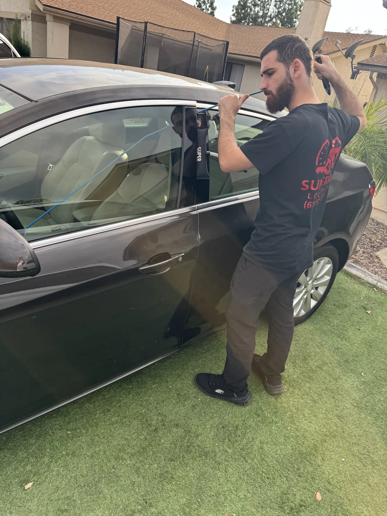 Technician unlocking a car with a long-reach tool